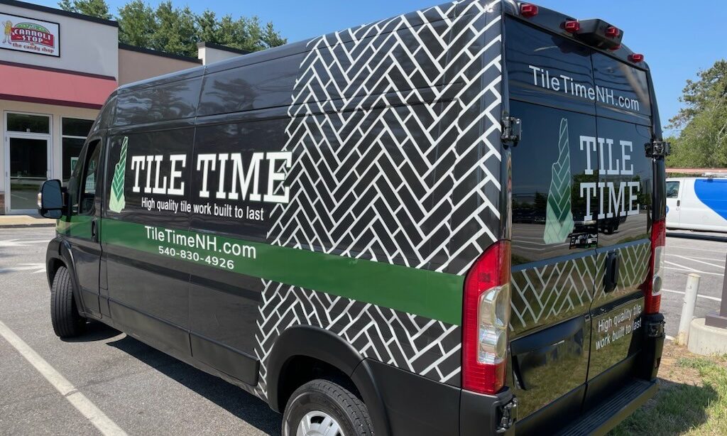 Black commercial van with custom vinyl graphics and letter decals for business fleet branding. Premium mobile installation available for dealerships.